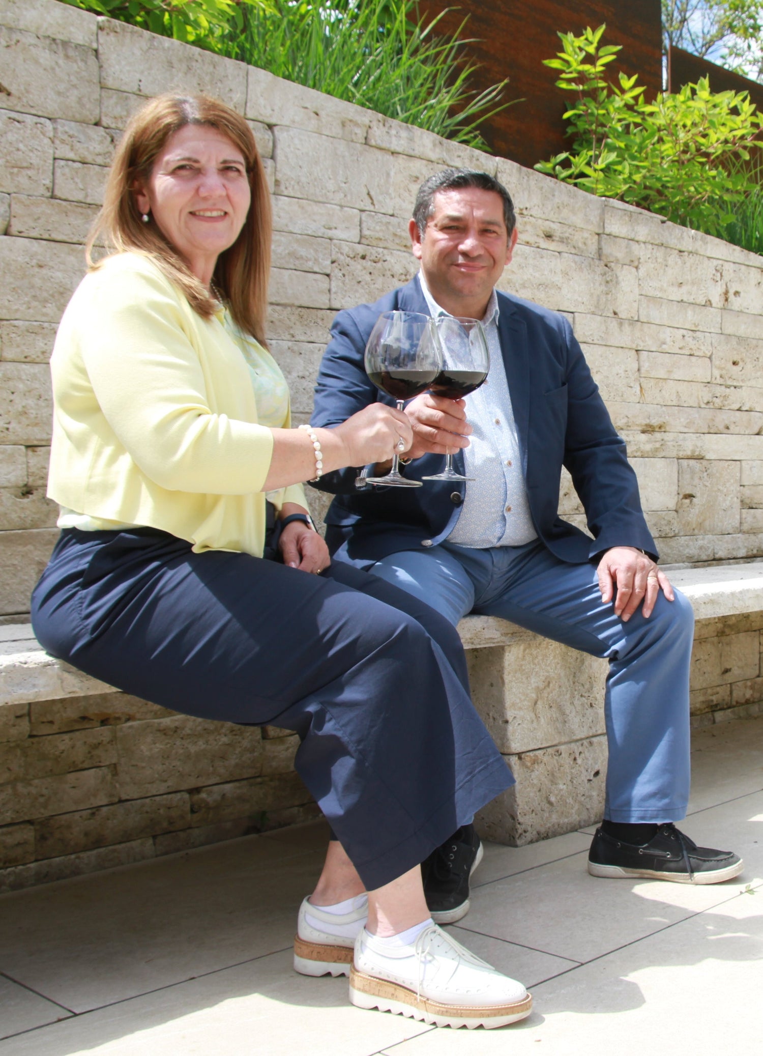 Katia und Geatano Di Salvo trinken zusammen Wein auf einer Steinbank, Weinhandel, Tanowein